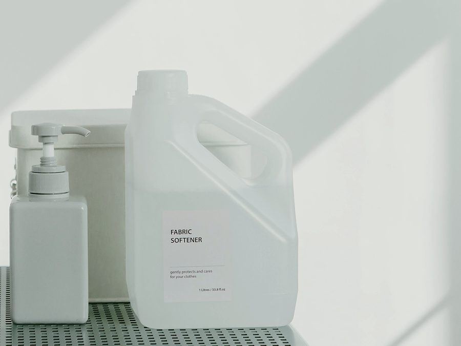 Fabric softener and laundry liquid containers on a shelf