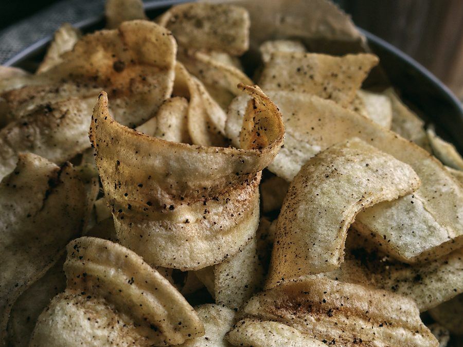 Seasoned potato crisps in a bowl with a cold drink
