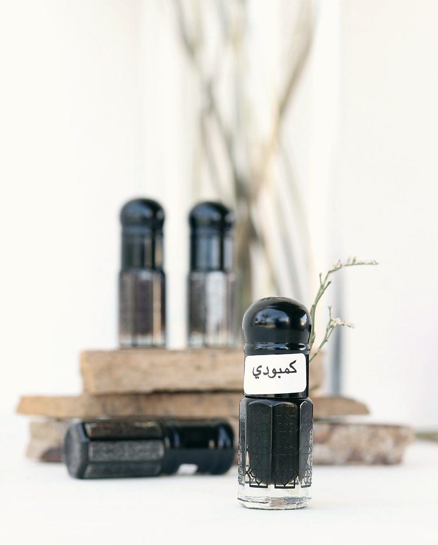 Oud attar concentrate bottles resting on agarwood